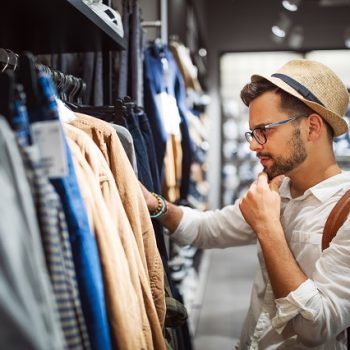 Handsome man shopping for new clothes in store
